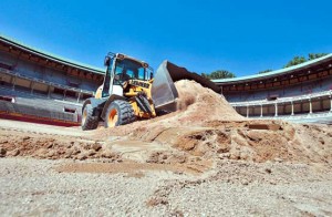 Una máquina trabaja en la retirada de la arena extendida hace un año en la plaza de toros. Fotografía: Calleja.
